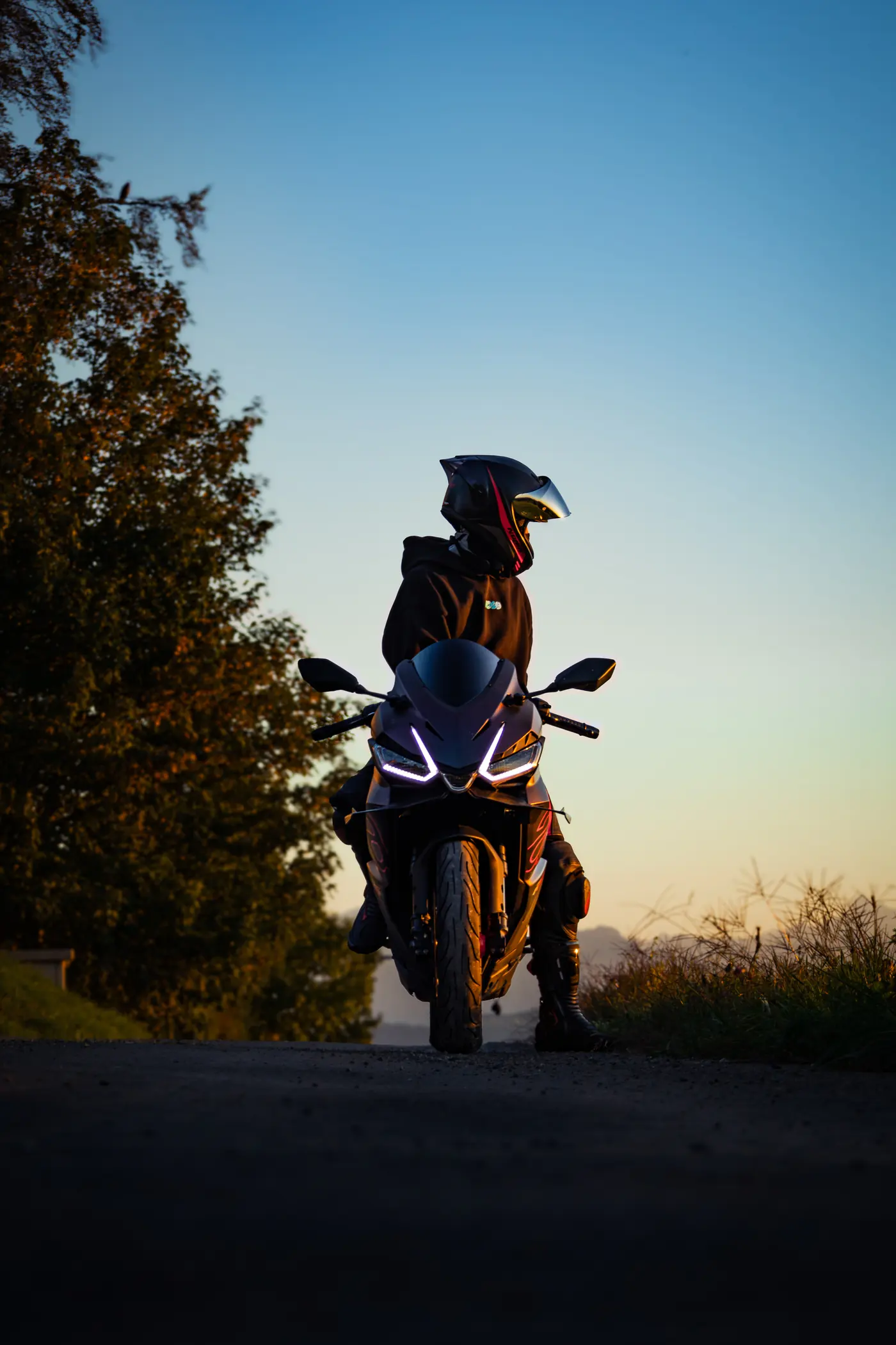 Motorradfahrer auf seinem Motorrad im Abendlicht