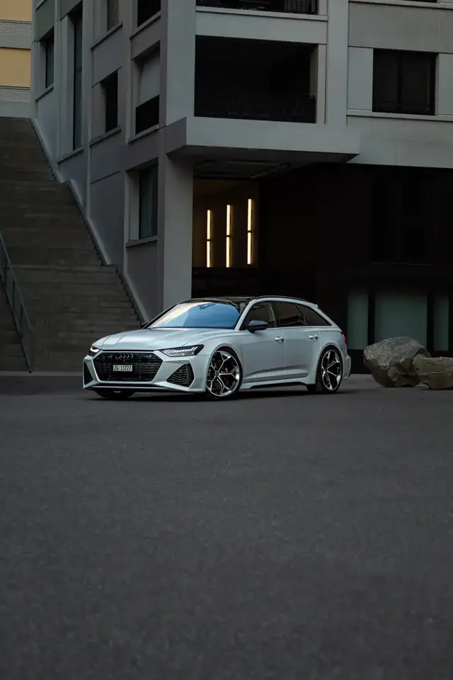 Weisser Audi RS6 Avant vor Treppe und Betonfassade